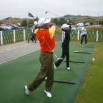 Mr. and Mrs. Hodge swinging in sync on the range at the Castle Course. — at Castle Course.